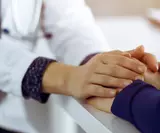 Врач держит руки пациента в своих руках